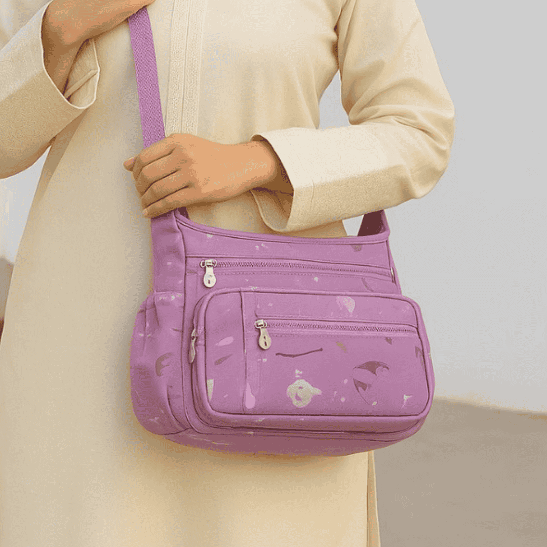 pruple crossbodybag with colorful abstract patterns branded 'Al Mishqaat'.