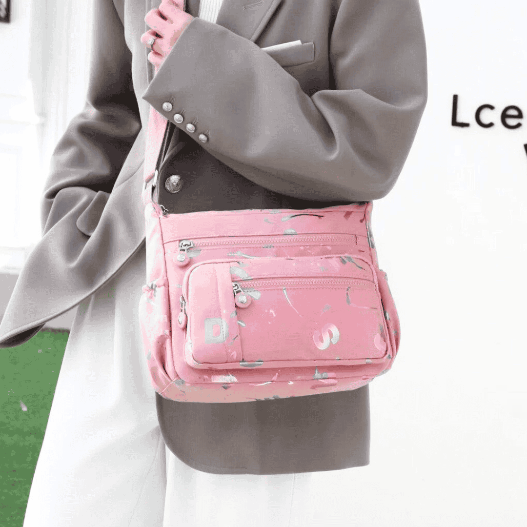 Large stylish crossbody alphabet bag in lavender with multicolor letter print, featuring multiple zippered compartments for fashion and versatility.

