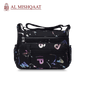 Black handbag with colorful abstract patterns branded 'Al Mishqaat'.