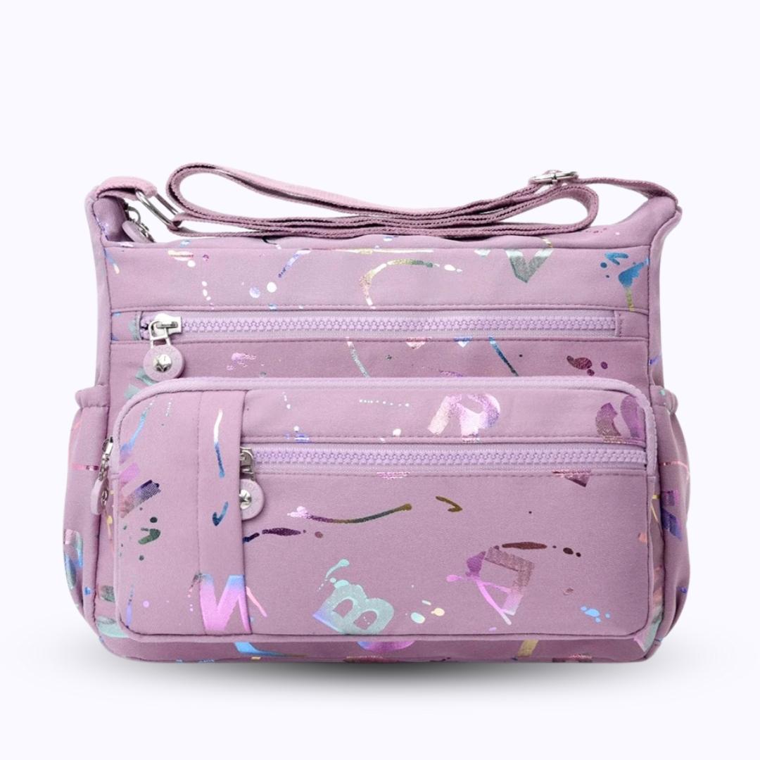 Large stylish crossbody alphabet bag in lavender with multicolor letter print, featuring multiple zippered compartments for fashion and versatility.