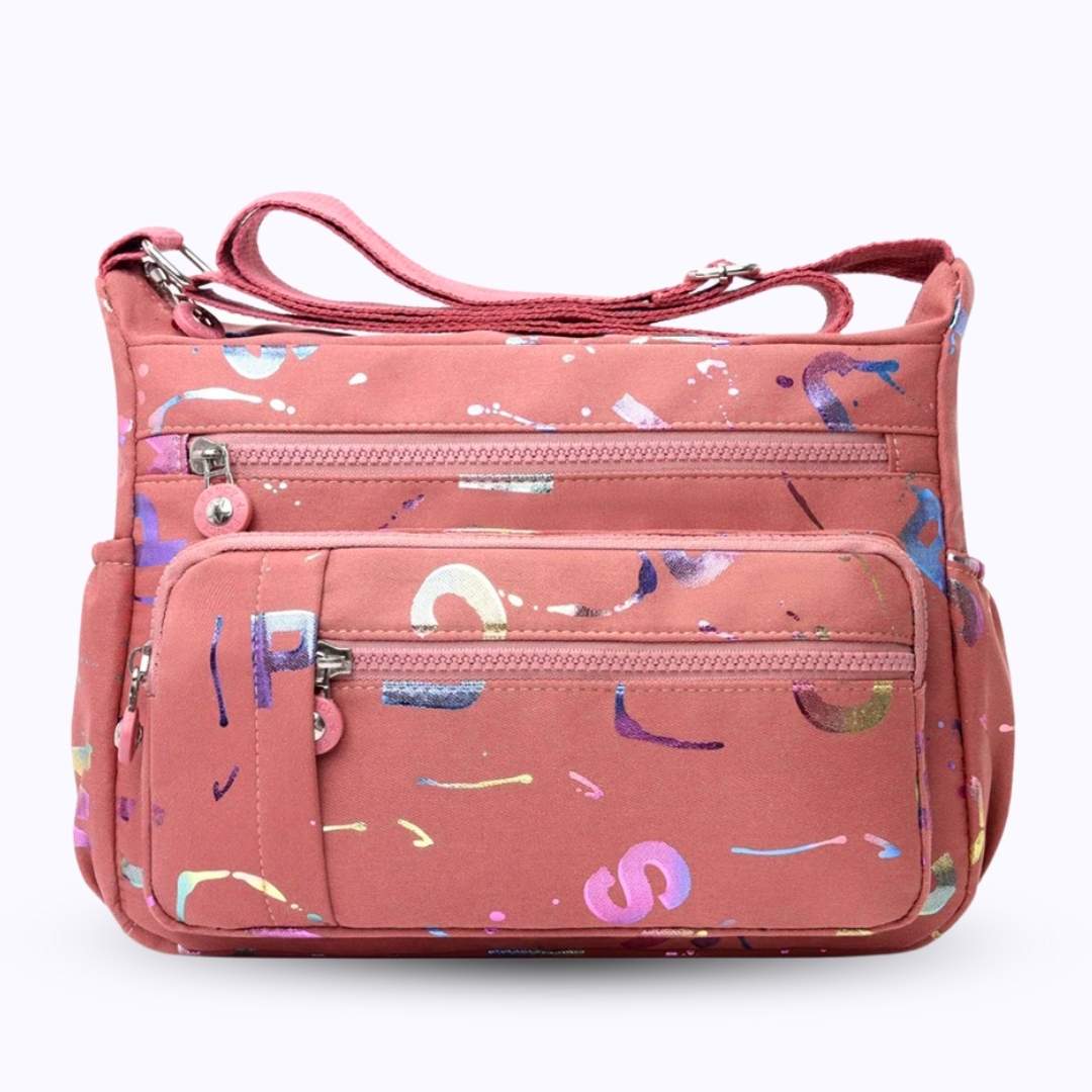 Large stylish crossbody alphabet bag in pink with multicolor letter prints, featuring multiple zippered compartments and adjustable shoulder strap.