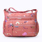 Large stylish crossbody alphabet bag in pink with multicolor letter prints, featuring multiple zippered compartments and adjustable shoulder strap.