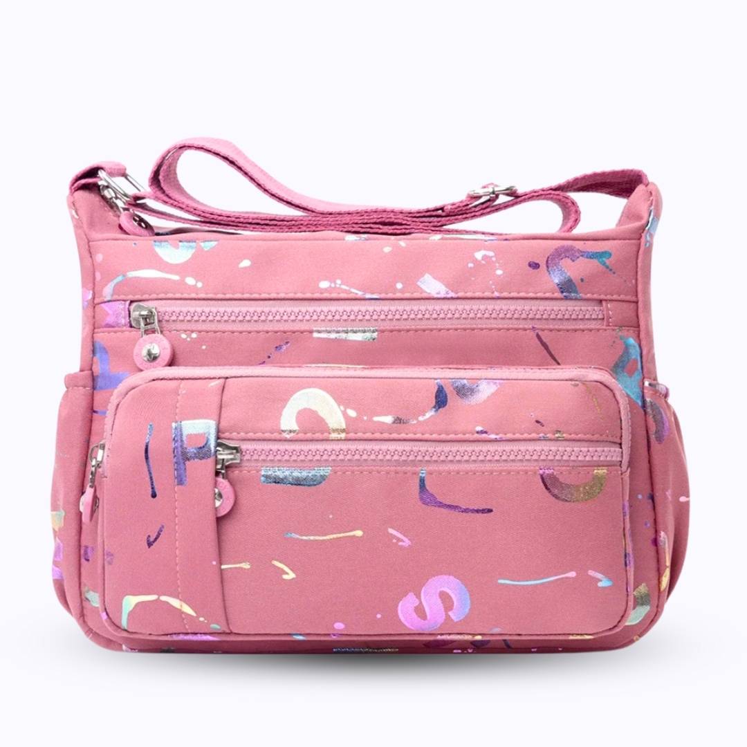 Large stylish crossbody alphabet bag in lavender with multicolor letter print, featuring multiple zippered compartments for fashion and versatility.
