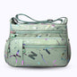Large stylish crossbody alphabet bag in sage green with multicolor paint splatter and bold letter prints, ideal for fashion-forward versatility.